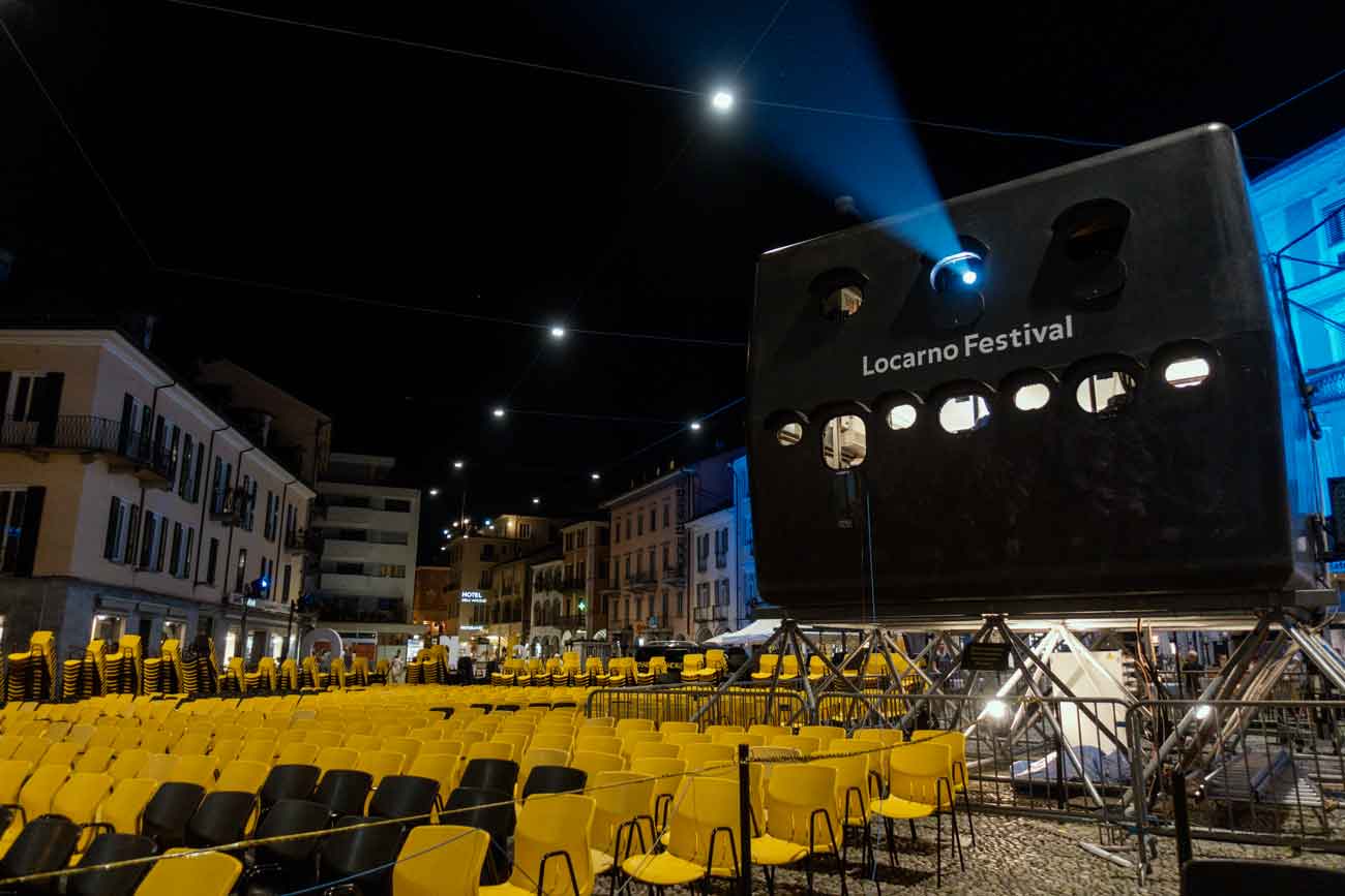 Ein riesengroßer Beamer steht neben den Sitzplätzen der Filmfestspiele in Locarno